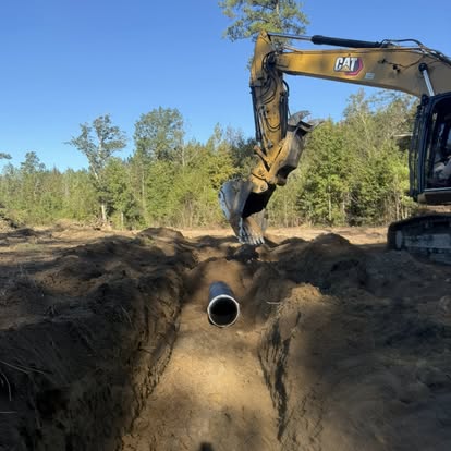Construction site earth moving with heavy equipment and cleared land.