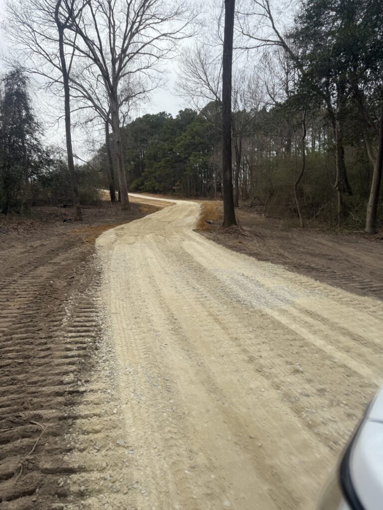 Field with grading work and construction machines preparing soil.
